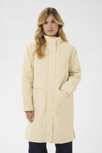 Woman wearing a beige coat on a white background