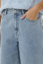 Light blue jeans worn by a person with a light blue textured top.