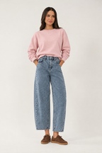 Jeans styled with a pink sweatshirt and brown suede trainers