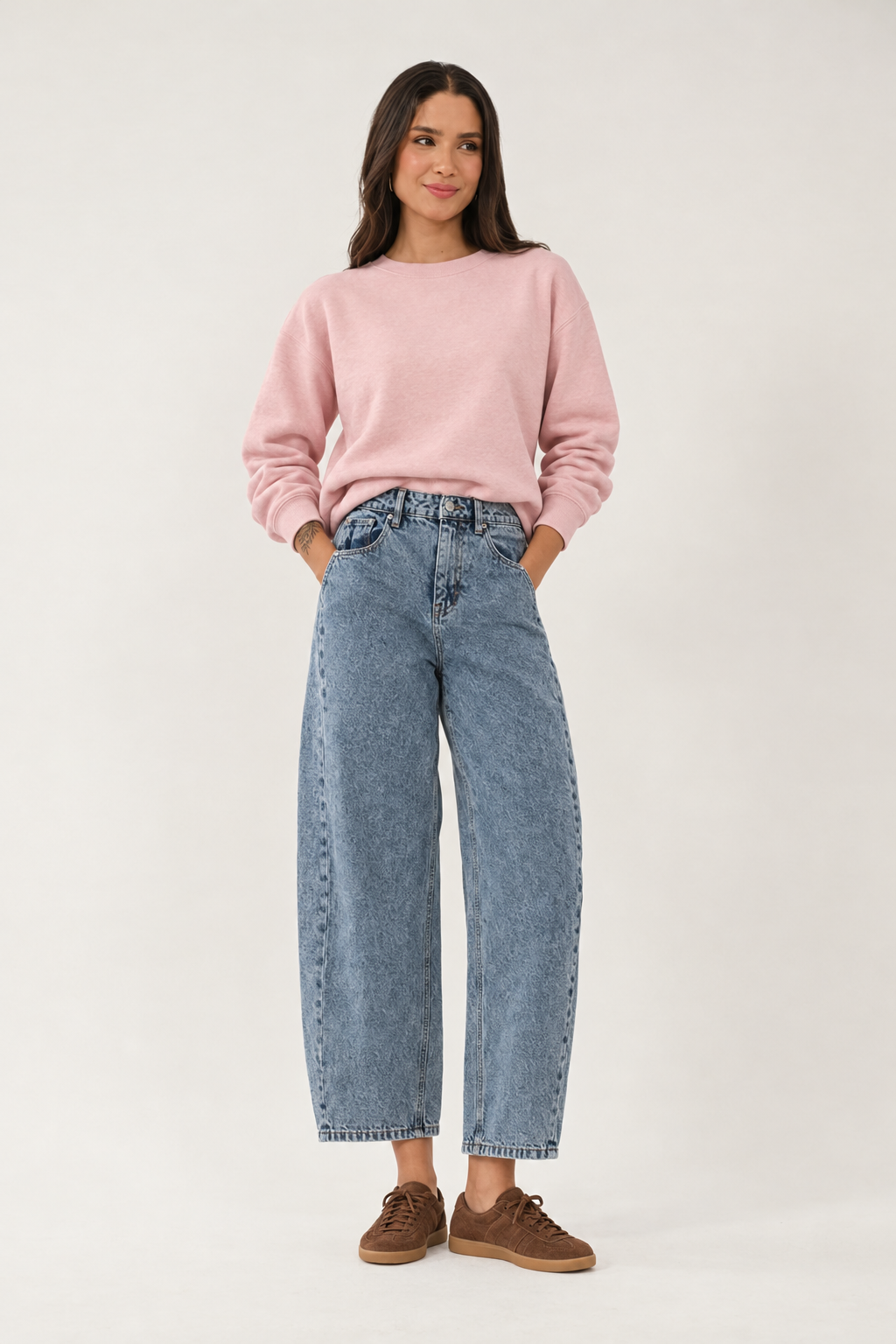 Jeans styled with a pink sweatshirt and brown suede trainers